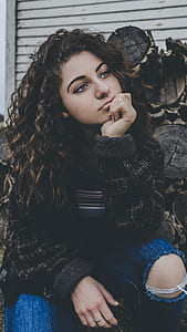 woman wearing black sweater near pile of wood thumbnail