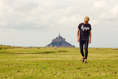 man in black t-shirt walking on grass field thumbnail