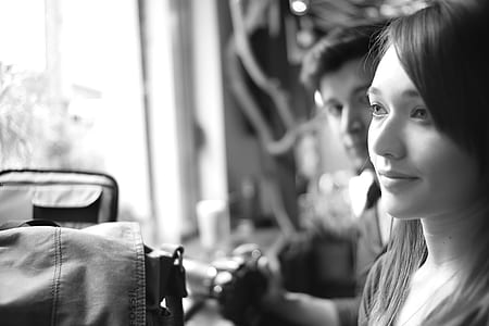 Grayscale Photo of a Woman Being Stared by a Man Inside a Room thumbnail