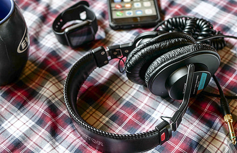 black and gray corded headphones beside smartwatch thumbnail