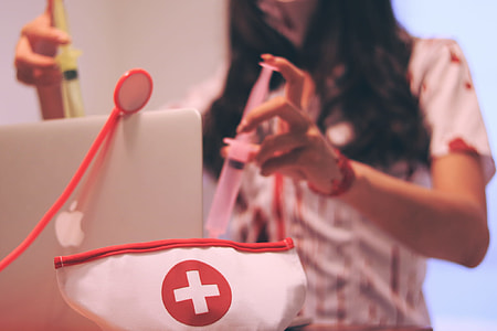 girl holding a syringe near the white and red cross printed decor thumbnail