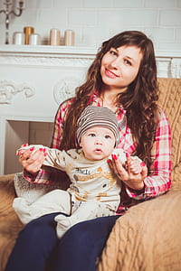woman in red and brown plaid dress shirt holding baby thumbnail
