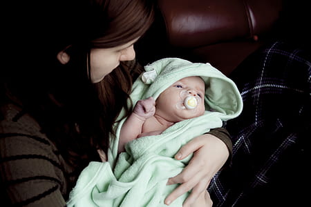woman carrying baby with pacifier thumbnail