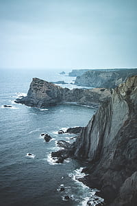 brown rock mountain near body of water thumbnail