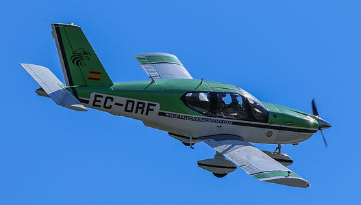 green and grey crop duster against blue sky thumbnail