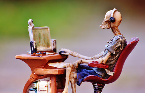 skeleton sitting on chair facing monitor figurine thumbnail