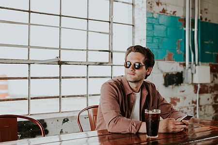 man in white top sitting in front of table thumbnail