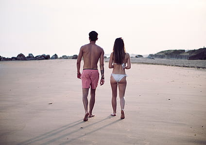women's white bikini and men's red beach short thumbnail