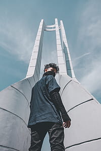 man standing below tower thumbnail
