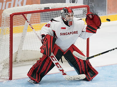 Singapore hockey goalie player standing behind goalie net inside hockey rink thumbnail