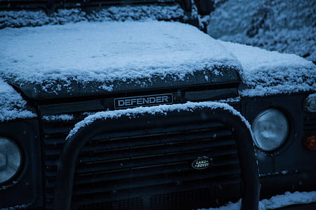 black Defender vehicle filled with snow thumbnail