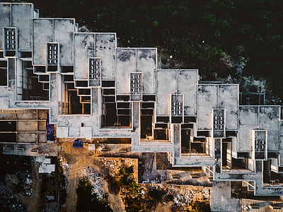 aerial view of concrete building near body of water thumbnail