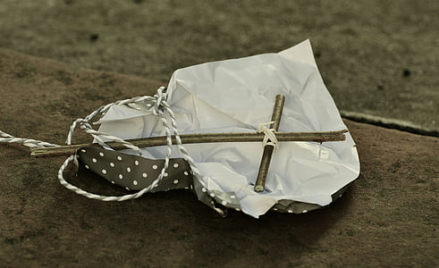 white cross on top of white and black paper thumbnail