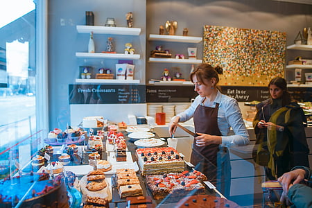 woman standing in front of variety of pastries thumbnail
