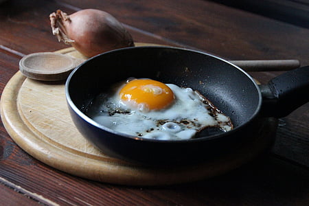 sunny side-up egg in frying pan near onion thumbnail