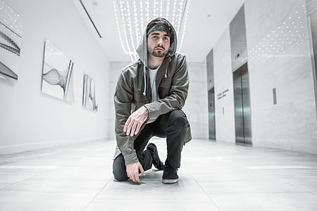 man in gray hoodie sitting on floor thumbnail
