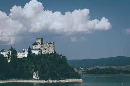 gray building on mountain top near sea thumbnail