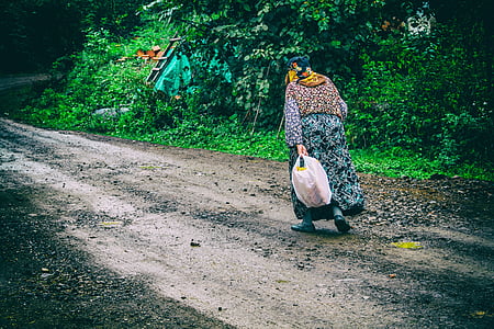 woman wearing green and black dress while carrying white plastic bag thumbnail