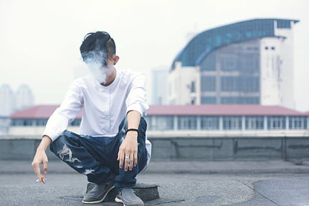 man sitting on the ground while smoking thumbnail