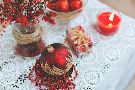 red and beige Christmas ornament beside vase thumbnail