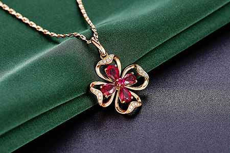 embellished Ruby gold 4-leaf clover necklace on green textile thumbnail