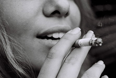 grayscale photo of woman smoking cigarette thumbnail