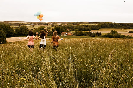 three women running on grass field during daytime thumbnail