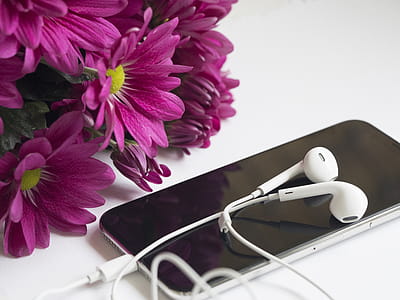 Close-Up Photography of Earphones on Top of Iphone 6 Near Flowers thumbnail