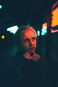 woman wearing black jacket standing beside orange LED light thumbnail