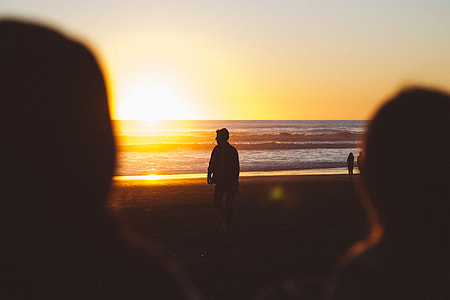 silhouette person walking on the seashore thumbnail