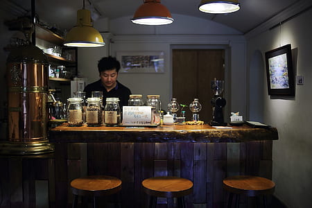 Man on Black Polo Shirt Is Standing Infront of Bar Counter thumbnail
