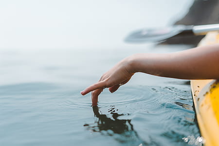 person touching body of water during daytime thumbnail