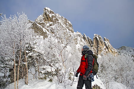 man standing near bare tree covered with snow thumbnail