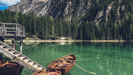 brown row boat on port near mountain thumbnail