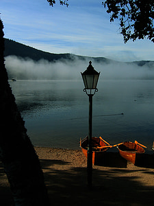 post lantern near two canoes on body of water thumbnail