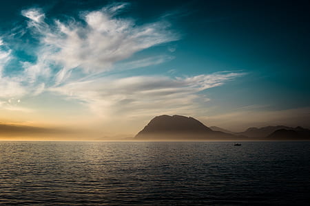 silhouette of mountain under cloudy sky thumbnail