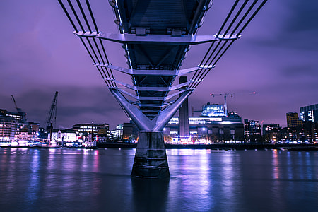 Long exposure shot captured under the Millennium Bridge in London on the River Thames thumbnail