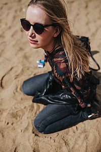 Young woman wearing a leather jacket and sunglasses on the beach thumbnail
