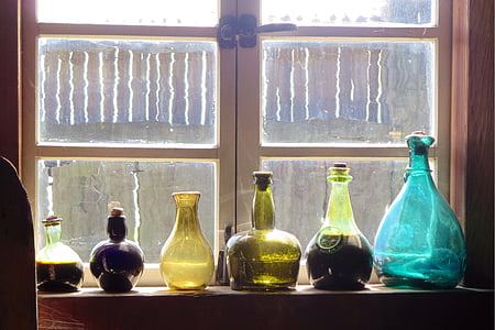 assorted-color several glass vases on window thumbnail