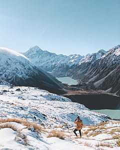 person walking down on snow capped mountain under blue sky thumbnail