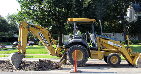 man riding on black and yellow front loader during daytime thumbnail