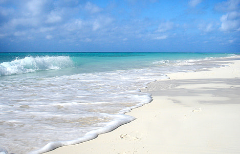 sand near body of water during sunny day thumbnail