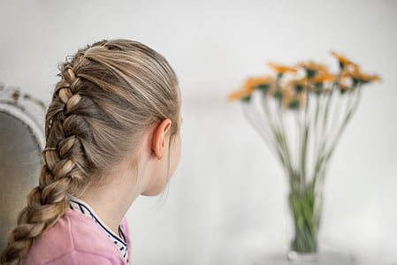 girl in pink shirt near yellow petaled flower thumbnail