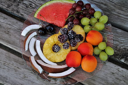 assorted fruits on plate placed on wood plank thumbnail