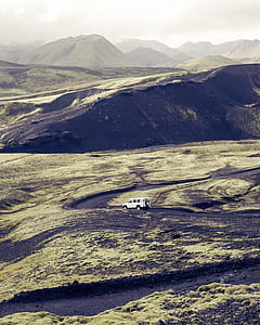 white SUV cruising curved road on plain terrain during daytime thumbnail