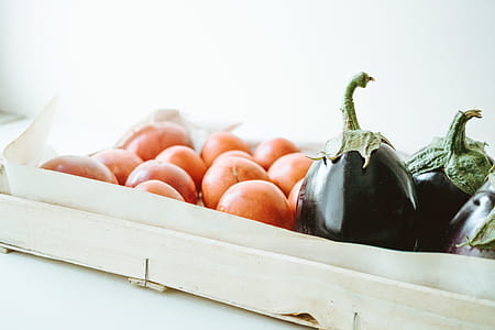 Close-up Photo of Purple Eggplants and Round Orange Fruits thumbnail