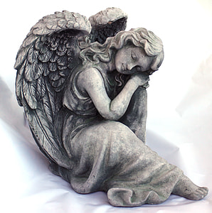 close up photo of gray angel statuette on white textile thumbnail
