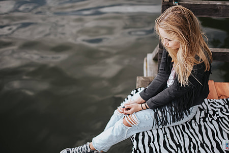 Blonde woman having a healthy snack at the wooden pier thumbnail