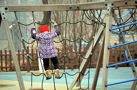 girl climbing on outdoor rope playset near leafless tree thumbnail