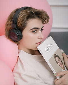 woman listening to headphones and hugging book thumbnail